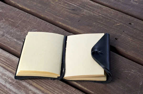 Leather bound black journal outdoors on table with blank pages — 스톡 사진
