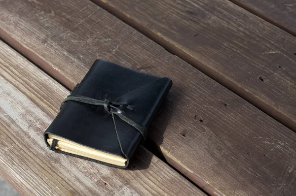 Cuero encuadernado negro diario al aire libre en la mesa — Foto de Stock