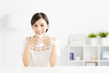 genç kadın oturma odasında sıcak latte kahve içme