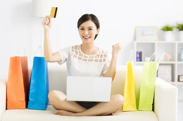 Lächelnde junge Frau beim Einkaufen mit Laptop — Stockfoto