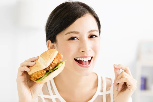 幸福的年轻女人吃大的汉堡包 — 图库照片
