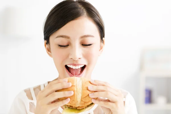 Happy young  woman eating  big hamburger — Stock Photo, Image