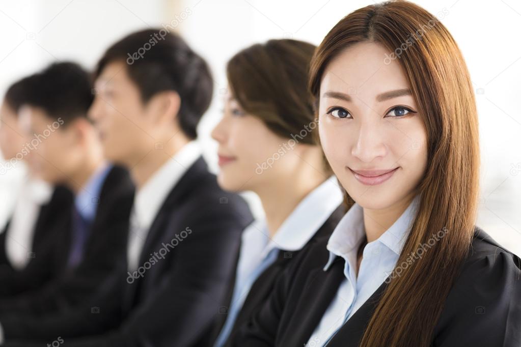Smiling businesswoman looking at camera with  colleague 