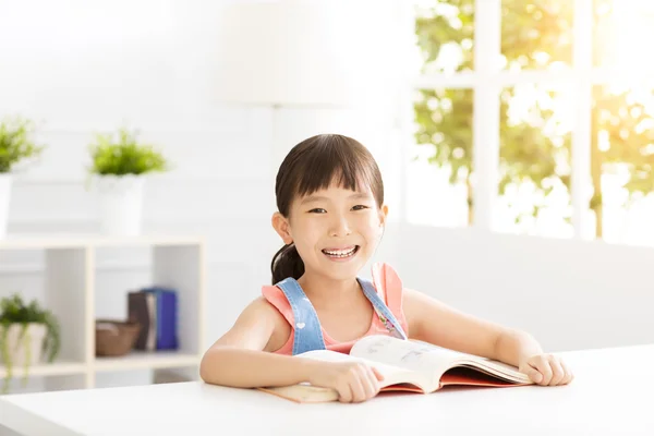 Glückliches kleines Mädchen studiert im Wohnzimmer — Stockfoto