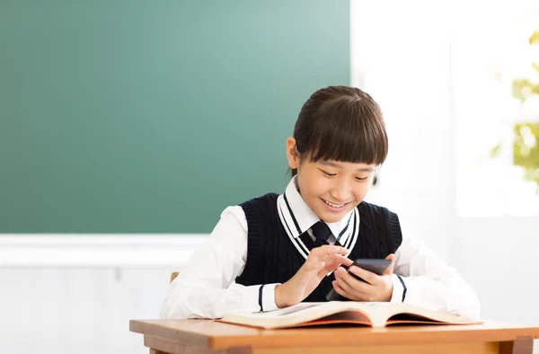 Glücklicher Schüler liest Smartphone im Klassenzimmer — Stockfoto