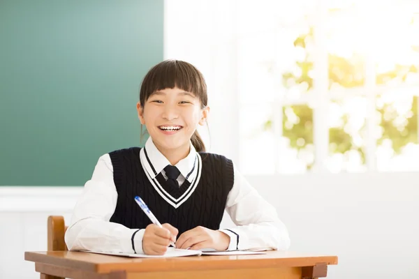 Szczęśliwy nastolatek dziewczyna badania w klasie — Zdjęcie stockowe