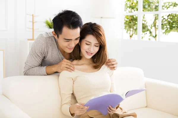 Young couple spending time reading together on sofa — ストック写真