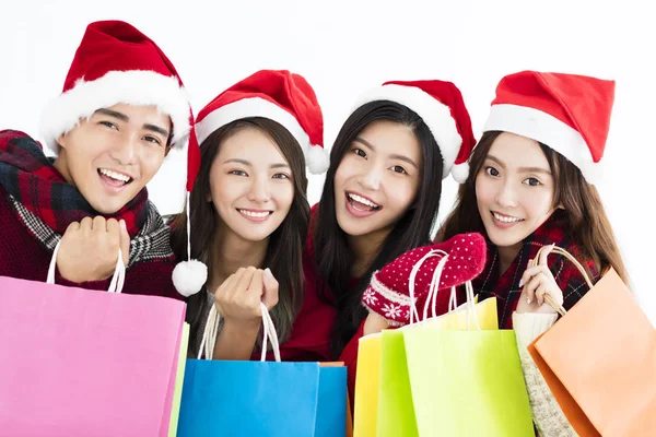 Feliz grupo de jóvenes en el sombrero de santa y compras juntos —  Fotos de Stock