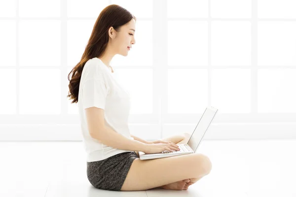 Jovem mulher sentada no chão com laptop — Fotografia de Stock