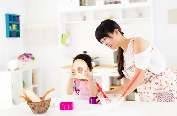 Küçük kız annesi mutfakta yemek hazırlamak yardım — Stok fotoğraf