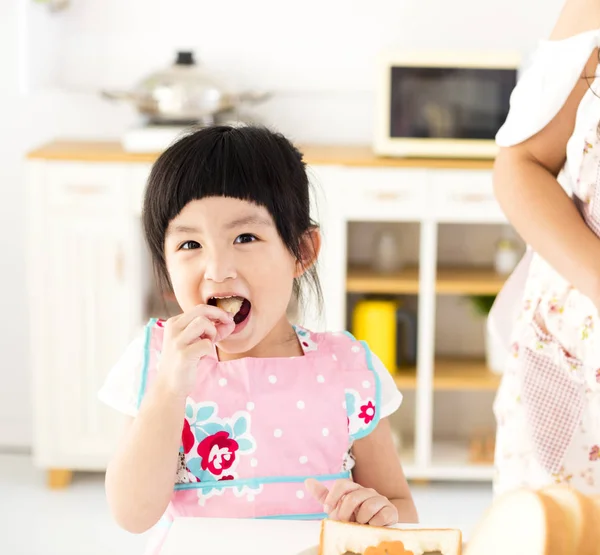 Menina bonita comendo na cozinha — Fotografia de Stock