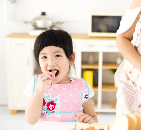 漂亮的小女孩在厨房吃东西 — 图库照片