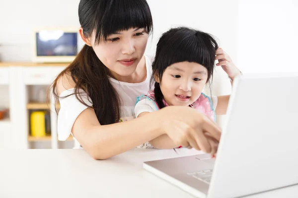 Mutter mit kleinem Mädchen benutzt Laptop in der Küche — Stockfoto