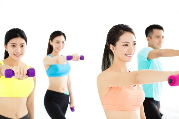 Sonriente joven en forma grupo estiramiento en el gimnasio —  Fotos de Stock