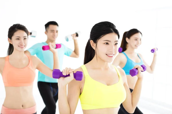 Sonriente joven en forma grupo estiramiento en el gimnasio —  Fotos de Stock