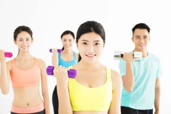 Lachende jonge passen groep die zich uitstrekt in sportschool — Stockfoto