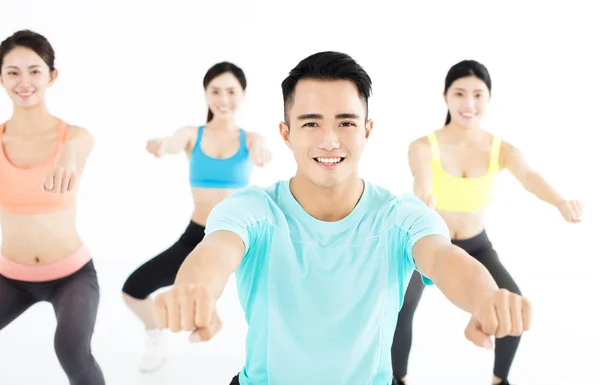 Sonriente joven en forma grupo estiramiento en el gimnasio —  Fotos de Stock