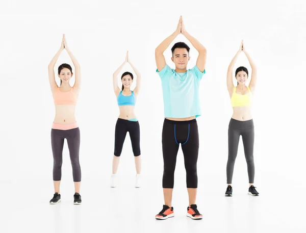 Sonriente joven en forma grupo estiramiento en el gimnasio —  Fotos de Stock