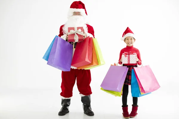 Lycklig liten flicka och santa claus håller kassar och påsar — Stockfoto