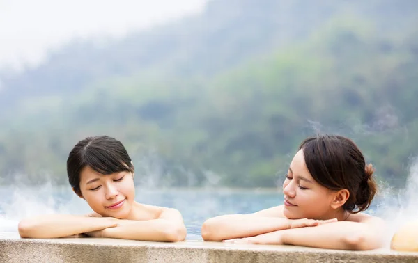 Jovem mulher feliz relaxando em fontes termais — Fotografia de Stock