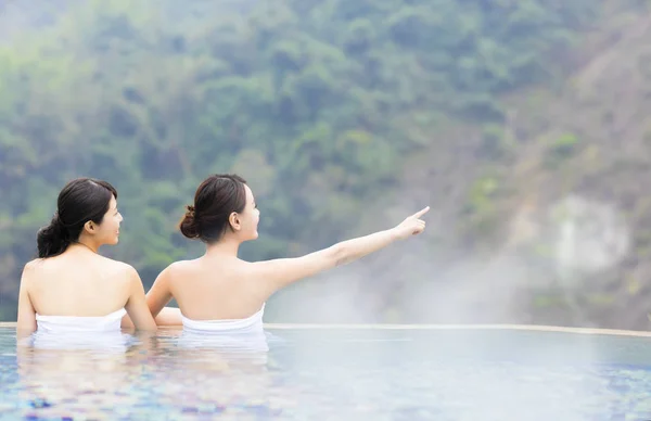 Jovem mulher feliz relaxando em fontes termais — Fotografia de Stock