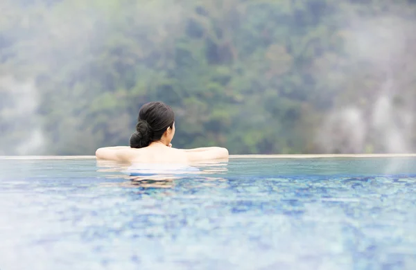Ung kvinna avkopplande i hot springs — Stockfoto