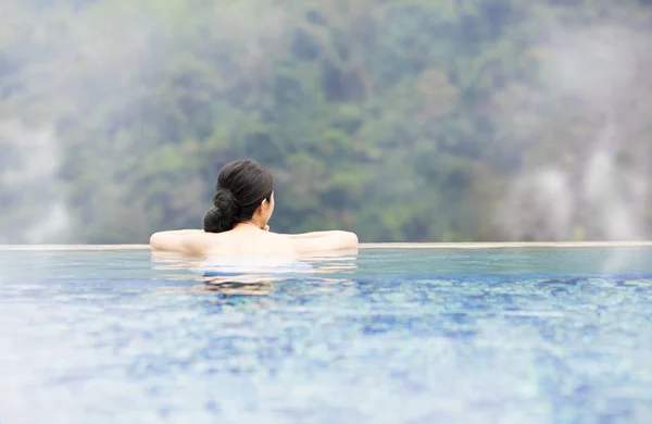 Jovem mulher relaxante em fontes termais — Fotografia de Stock