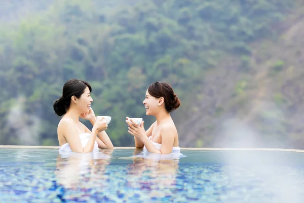 Jovem mulher feliz relaxando em fontes termais — Fotografia de Stock