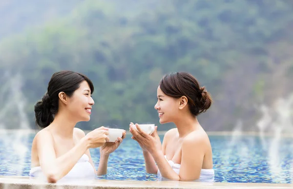 Jovem mulher feliz relaxando em fontes termais — Fotografia de Stock