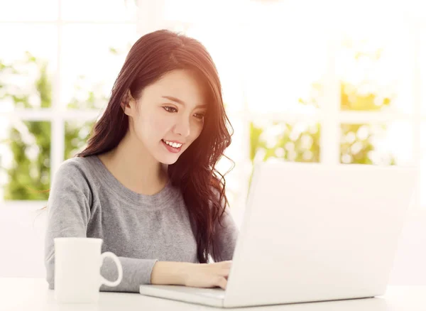 Glückliche schöne Frau arbeitet an einem Laptop — Stockfoto