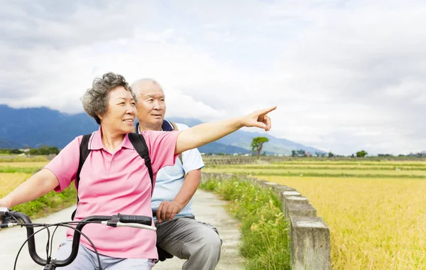 Heureux couple aîné équitation vélo sur la route de campagne — Photo