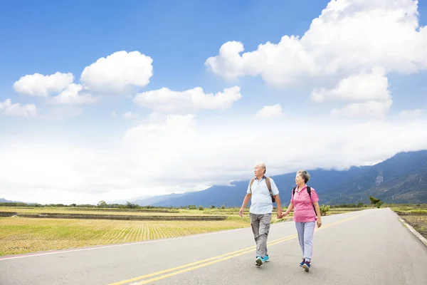 Äldre par vandring på landsvägen — Stockfoto