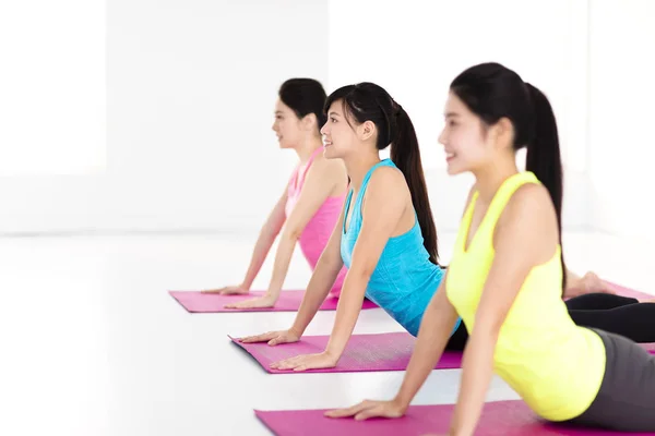 Fröhliche junge Frauengruppe macht Yoga-Übungen — Stockfoto