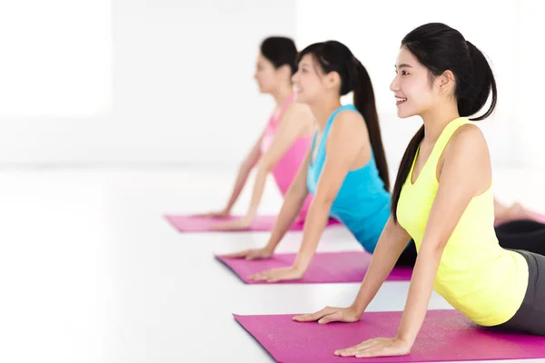 Fröhliche junge Frauengruppe macht Yoga-Übungen — Stockfoto