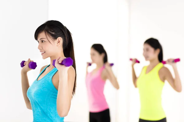 Jeune femme faisant de l'exercice avec haltère dans la salle de gym — Photo