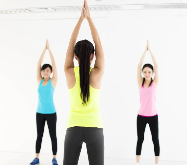 Leende ung grupp stretching i gymmet — Stockfoto