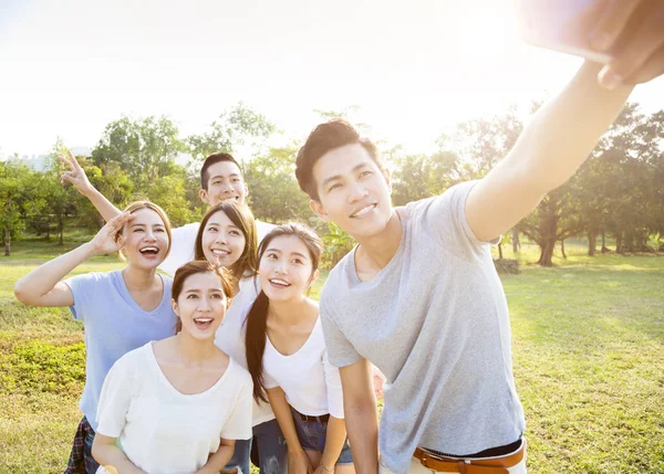 Szczęśliwa młoda Grupa biorąc selfie w parku — Zdjęcie stockowe