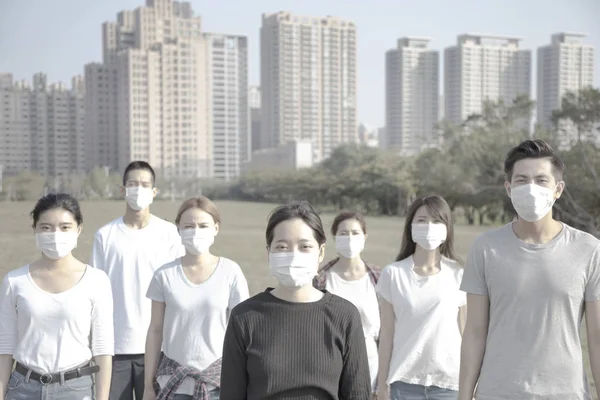 Jeune groupe portant un masque buccal contre la pollution de l'air en ville — Photo