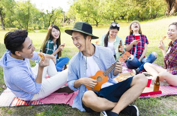 Grupo jovem feliz desfrutando de festa de piquenique — Fotografia de Stock