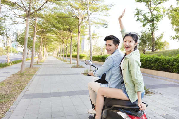 Pasangan muda bahagia naik skuter di kota — Stok Foto