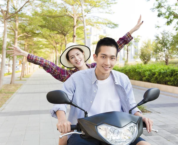 Happy young couple riding  scooter in town — Stock Photo, Image