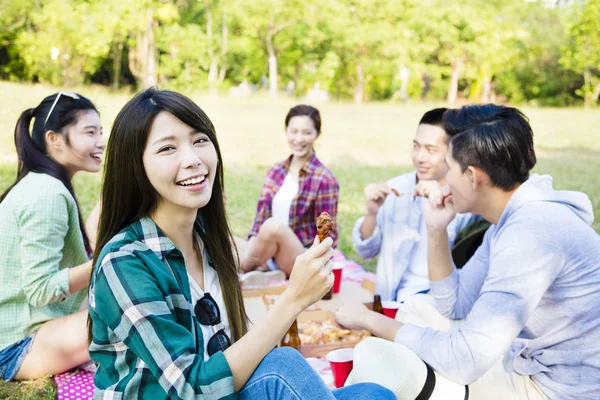 Jovens amigos felizes desfrutando de piquenique saudável — Fotografia de Stock