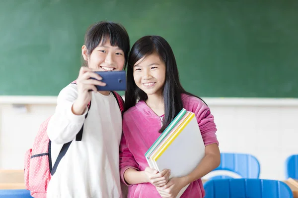 Twee tienermeisjes student maken selfie op de telefoon. — Stockfoto