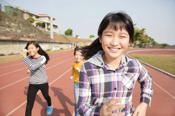 Meninas adolescentes felizes correndo na pista — Fotografia de Stock