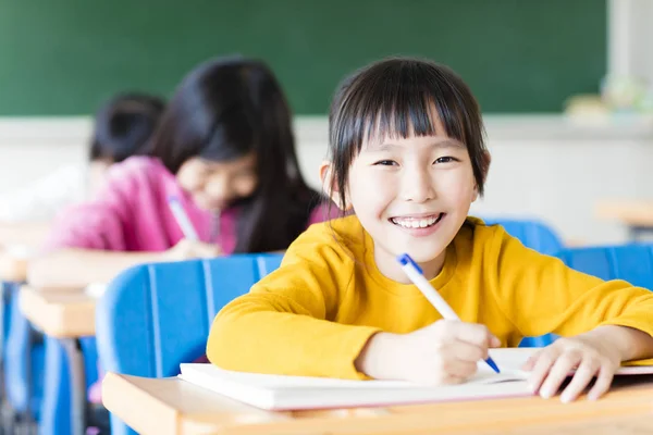 Gelukkig weinig meisje student studeert in de klas Stockfoto