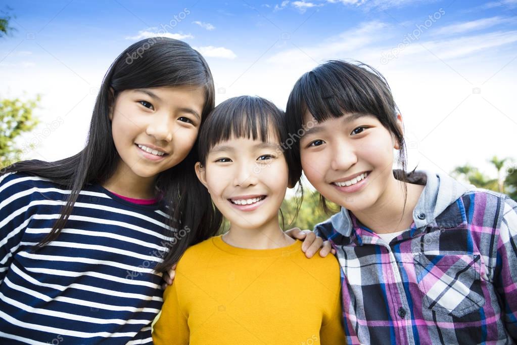 Three laughing attractive teens girlfriends