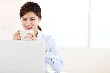 genç iş kadını ofiste dizüstü bilgisayar ile