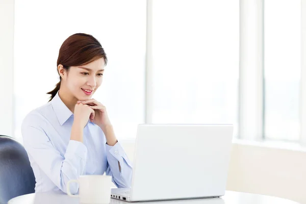 Jovem mulher de negócios com laptop no escritório — Fotografia de Stock