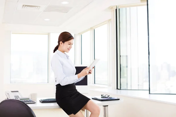 Jeune femme d'affaires avec tablette numérique au bureau — Photo