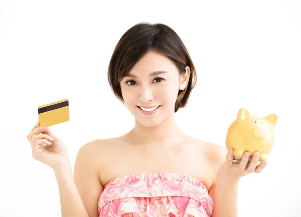 Young woman showing credit card and piggy bank — Stock Photo, Image